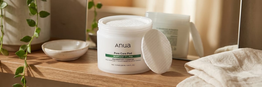 ANUA Heartleaf 77 Toner Pads jar on a clean linen surface with a single textured pad