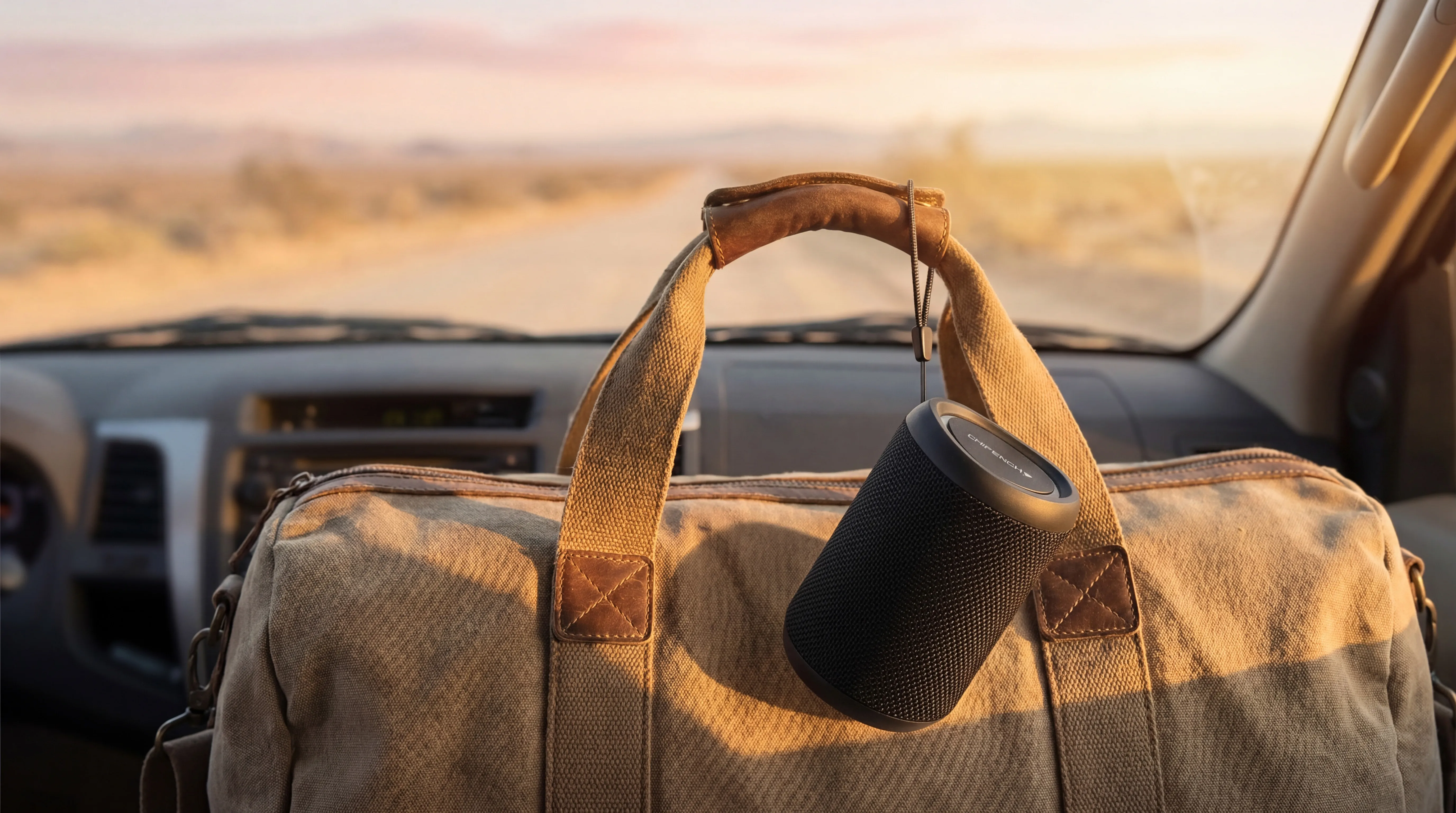 CHIFENCHY speaker clipped to a duffel handle on a road-trip dashboard
